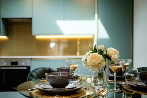 una mesa con platos y vasos y un jarrón de flores en Marble Arch Suite 8-Hosted by Sweetstay en Londres