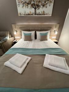 ein großes Bett mit zwei weißen Handtüchern drauf in der Unterkunft DeMar Apart Doroshenka in Lwiw