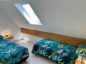 a bedroom with two beds and a skylight at House Botanique in Meise