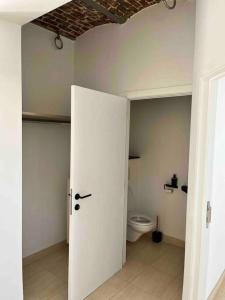 ein Bad mit einem WC und einer weißen Tür in der Unterkunft House Botanique in Meise