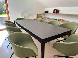 a conference room with a table and green chairs at House Botanique in Meise