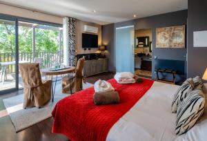 a bedroom with a large bed with a red blanket at Domaine de Chalvêches Hôtel SPA 4* in Faugères in Rhone-Alpes