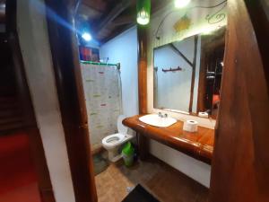 uma casa de banho com um lavatório, um espelho e um WC. em Hotel Bambu Mompiche em Mompiche