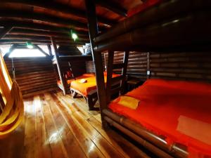 a room with two beds and a wooden floor at Hotel Bambu Mompiche in Mompiche