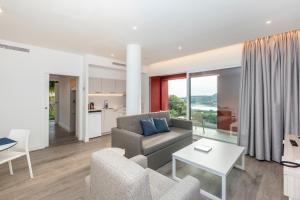 a living room with a couch and a table at HG Jardín de Menorca in Son Bou