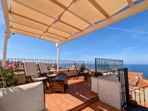 a patio with chairs and a view of the ocean at Panorama Guest House in Alghero