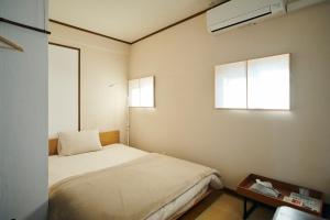 um pequeno quarto com uma cama e uma janela em Kohaku em Nara