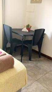 Una mesa negra con dos sillas y una planta. en Sarmiento Monoambiente en Concordia