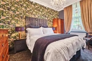 1 dormitorio con cama y papel pintado con motivos florales en The Lawrence, en Derry Londonderry