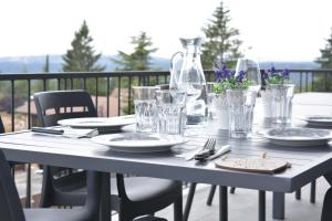 a table with plates and glasses on a balcony at La Atalaya in Las Navas del Marqués