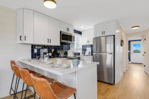 a kitchen with white cabinets and a kitchen island with chairs at Sandy Toes in Salisbury
