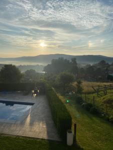 Elle offre une vue sur une arrière-cour avec une piscine et le coucher du soleil. dans l'établissement Casa de Porto, à Barro