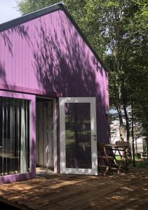 un edificio púrpura con una puerta en una cubierta en Cabanas da Ulla, en Touro