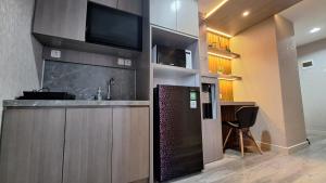 a kitchen with a bar with a tv on the wall at The Alton Apartemen Type Studio in Jatingaleh