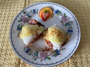 een bord met twee eieren en een aardbei bij Seabank House Bed and Breakfast Hummingbird in Pictou