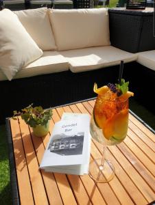 einen Tisch mit einem Getränk und ein Buch darauf in der Unterkunft Hotel Jungfrau Mürren in Mürren
