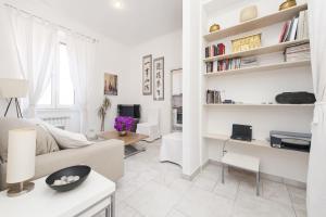 ein weißes Wohnzimmer mit einem Sofa und einem Tisch in der Unterkunft Foscolo al 24 in Rom