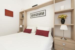 ein Schlafzimmer mit einem großen weißen Bett mit roten Kissen in der Unterkunft Foscolo al 24 in Rom