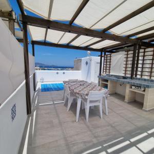 d'une terrasse sur le toit avec une table et des chaises. dans l'établissement CASA TURCHESE, à Favignana