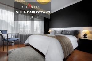 a hotel room with a white bed and a chair at The Queen Luxury Apartments - Villa Carlotta in Luxembourg