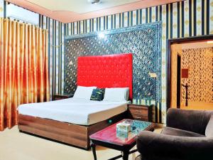 1 dormitorio con 1 cama, 1 silla y 1 mesa en Moon Soon Hotel, en Lahore