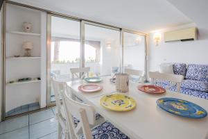 a dining room with a white table with plates on it at Luxurious apartment by the sea in Vietri sul Mare