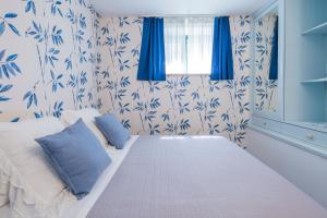 a bedroom with a bed with blue and white wallpaper at Luxurious apartment by the sea in Vietri sul Mare