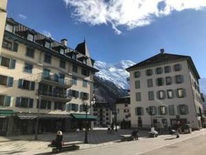 eine Stadtstraße mit Gebäuden und einem Berg im Hintergrund in der Unterkunft Charmant appartement au centre de Chamonix, 4 pers, parking - FR-1-507-59 in Chamonix-Mont-Blanc