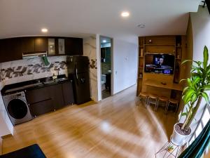 a kitchen with wooden floors and a living room at Cómodo apartamento tipo Loft en centro de Bogotá 5 in Bogotá