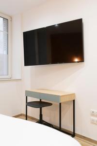 een bureau in een kamer met een tv aan de muur bij L'Annexe Metz Cathédrale in Metz