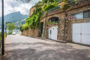 a stone building with two white garage doors on a street at Luxurious apartment by the sea in Vietri sul Mare