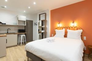 een slaapkamer met een groot wit bed en een keuken bij L'Annexe Metz Cathédrale in Metz