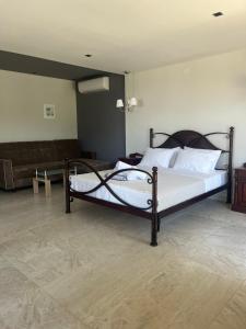 a bedroom with two beds and a couch at Suites Ris in Néa Péramos