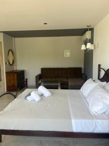 a bedroom with a large bed and a couch at Suites Ris in Néa Péramos