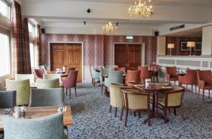 a restaurant with tables and chairs in a room at Bell by Greene King Inns in Thetford