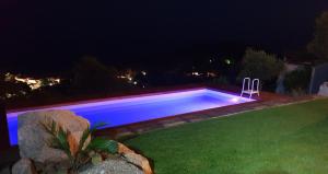 una piscina en el patio por la noche en Villetta con piscina panoramica Belvedere Mari Pintau, en Geremèas