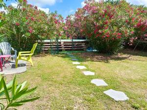 - un jardin avec une table, des chaises et des fleurs roses dans l'établissement Maison de 2 chambres avec piscine privee jardin clos et wifi a Maillane, à Maillane