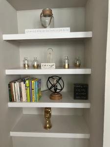 a room with white shelves with books and a clock at Cowtown 1 bedroom in Downtown FT Worth in Fort Worth