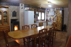 a kitchen with a table and chairs and a fireplace at El Descanso del Talegones in Torrevicente