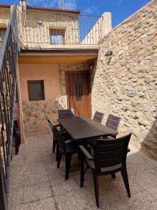 a wooden table and chairs in front of a building at El Descanso del Talegones in Torrevicente