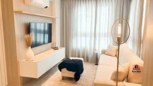 a living room with a television and a white couch at VILLA DI TONDO HOUSE - APARTAMENTO ESPETACULAR in Bento Gonçalves