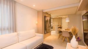 uma sala de estar com um sofá branco e uma mesa em VILLA DI TONDO HOUSE - APARTAMENTO ESPETACULAR em Bento Gonçalves