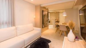 a living room with a white couch and a table at VILLA DI TONDO HOUSE - APARTAMENTO ESPETACULAR in Bento Gonçalves