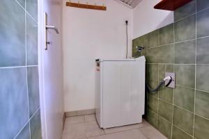 a white refrigerator in a bathroom with a tiled wall at Apartments Srdoc in Šilo