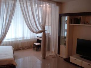 a bedroom with a bed and a television and curtains at Apartment in Most City, center in Dnipro