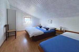 a bedroom with two beds and a white ceiling at Apartments Srdoc in Šilo