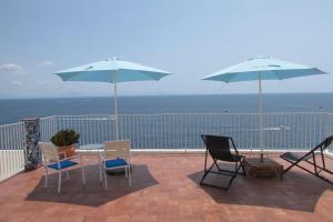 a patio with a table and chairs and umbrellas at Domus Claudia in Atrani
