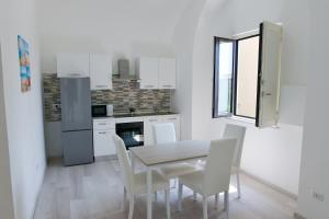 a kitchen with a table and chairs in a room at L'Aurora Azzurra -Luxury Suites in Piano di Sorrento