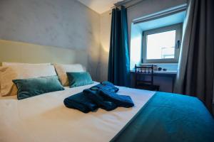 a bedroom with a bed with clothes on it at Casa do Sal in Albufeira