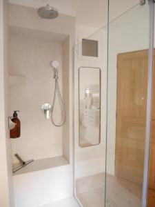 d'une douche avec une porte en verre et un miroir. dans l'établissement Le Clos des Confidences, à Grignan 22 autres photos